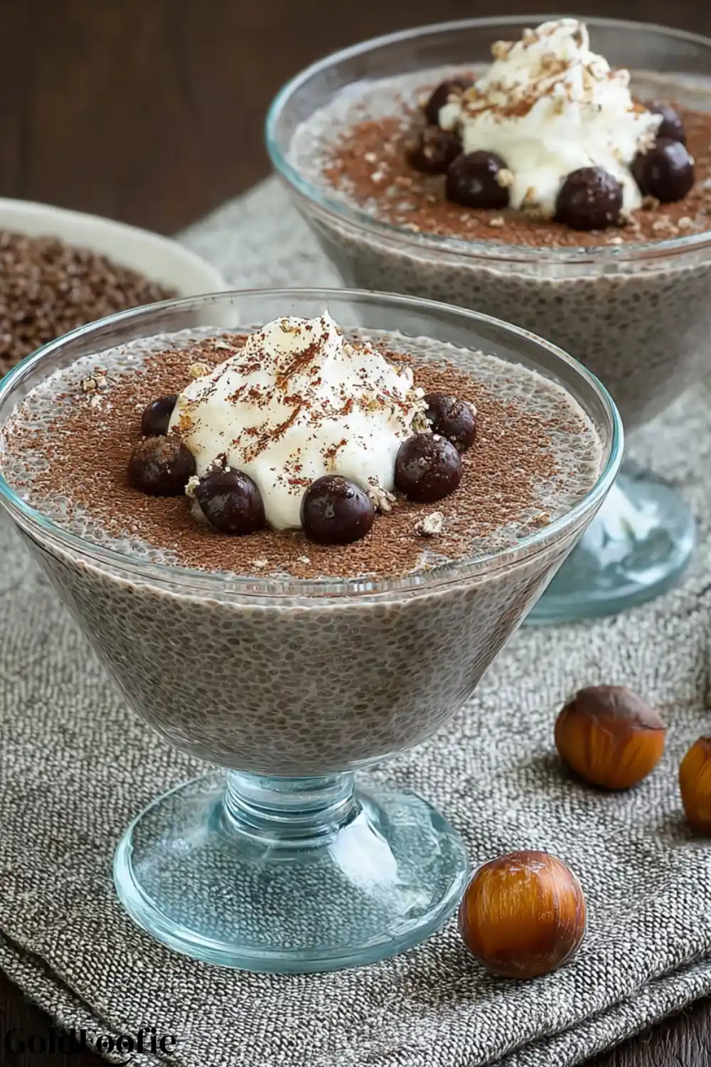 High-Protein Nutella Chia Pudding 5 Nutella chia pudding in glass bowls topped with whipped cream and chocolate-covered hazelnuts