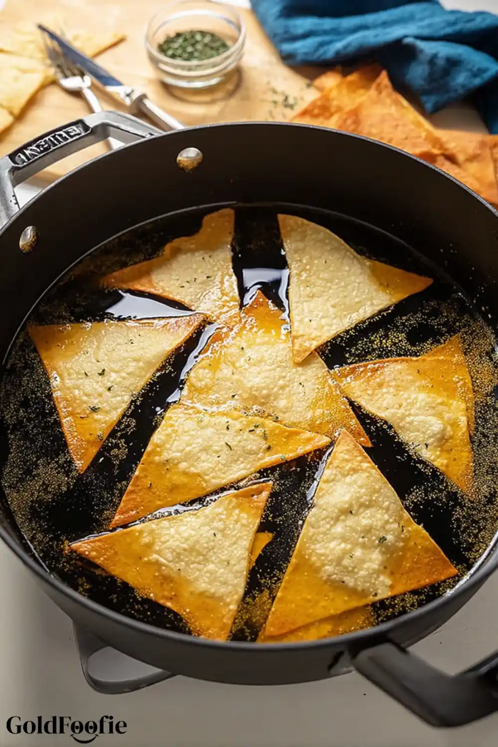 Frying Keto Chips in Avocado Oil Tortilla chips frying in oil in a black cast iron skillet
