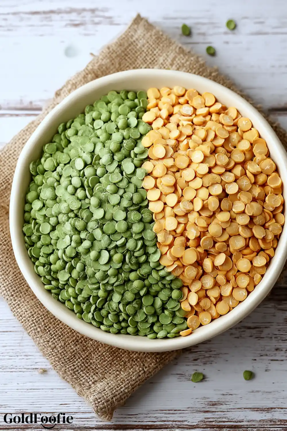 Green and Yellow Split Peas in a Bowl A bowl of green and yellow dried split peas on a wooden surface