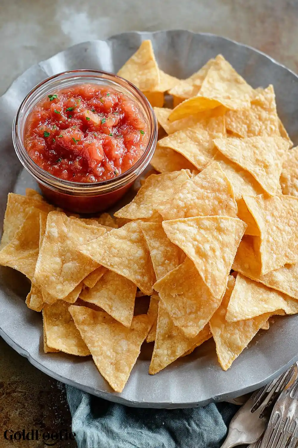 Low Carb Chips with Dipping Sauce Air Fryer Low Carb Tortilla chips on a plate with a small jar of salsa.