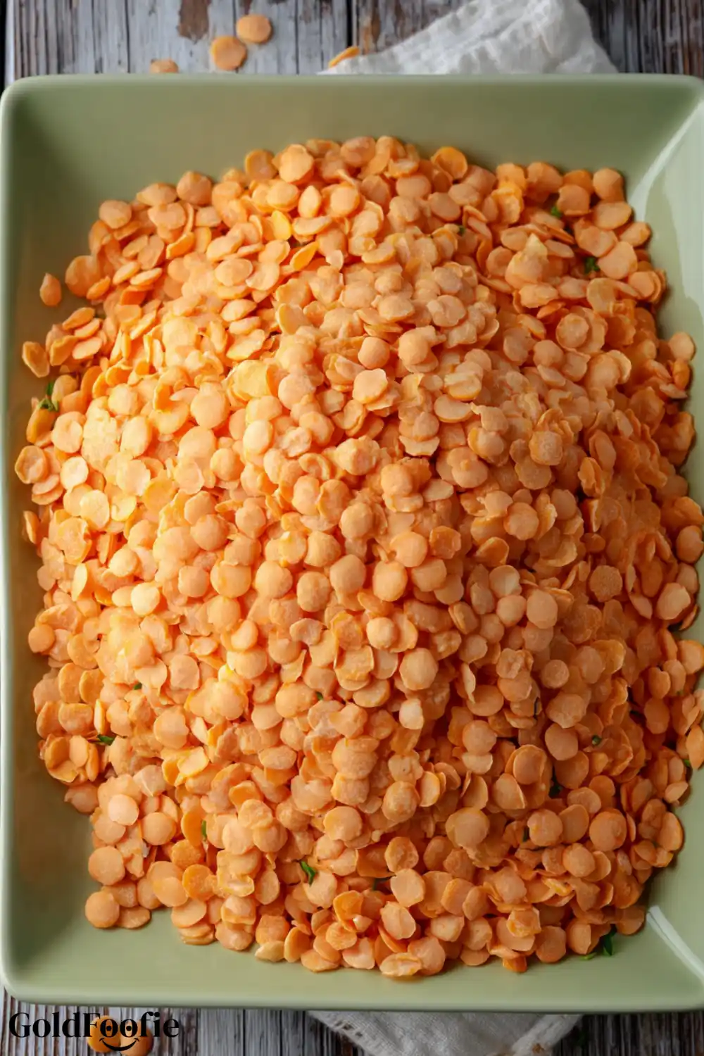 Raw Split Red Lentils A bowl filled with dry split red lentils on a rustic table