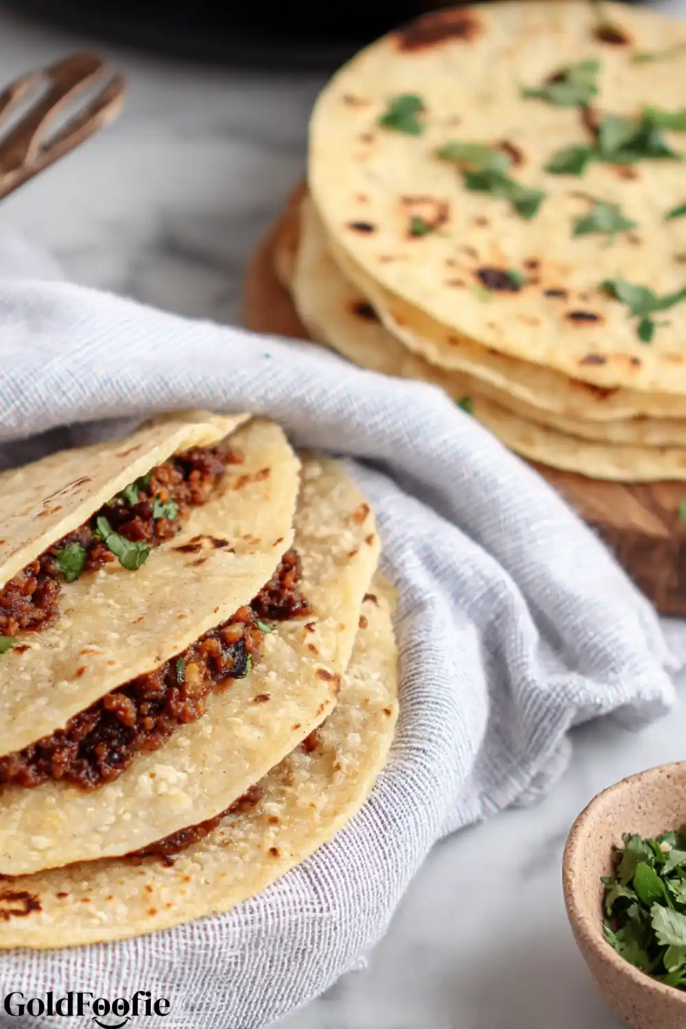 Stack of Homemade Keto Tortillas with Spicy Filling corn tortillas low carb stacked and filled with spicy meat on linen
