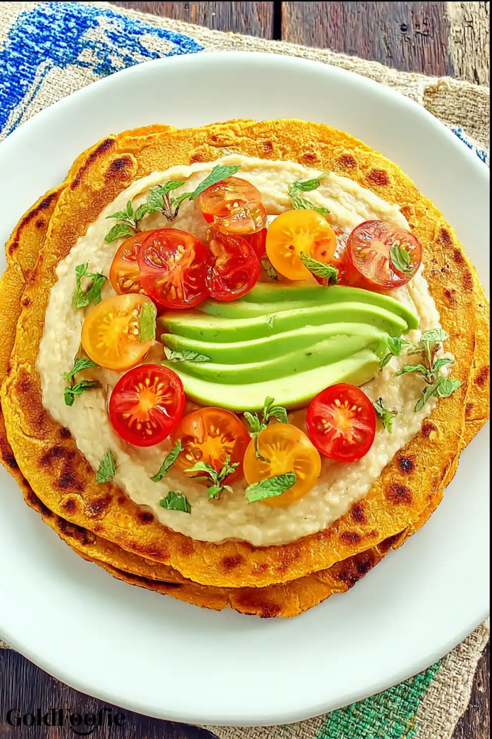 Sweet Potato Tortillas with Healthy Toppings Sweet potato tortilla topped with hummus, avocado slices, and cherry tomatoes