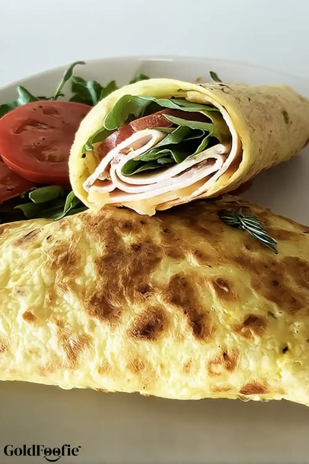 Cheese-Based Wrap with Fresh Greens and Tomato Cheese-based wrap with leafy greens and sliced tomatoes served with a side salad.