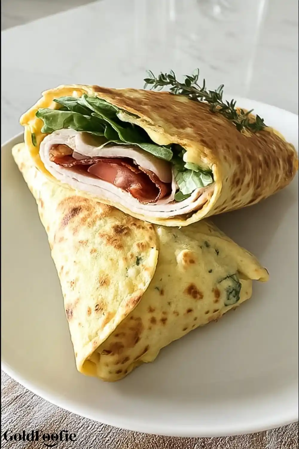 Cheese-Based Wrap with Turkey, Bacon, and Fresh Vegetables Two cheese-based wraps sliced in half showing layers of turkey, greens, and tomato.