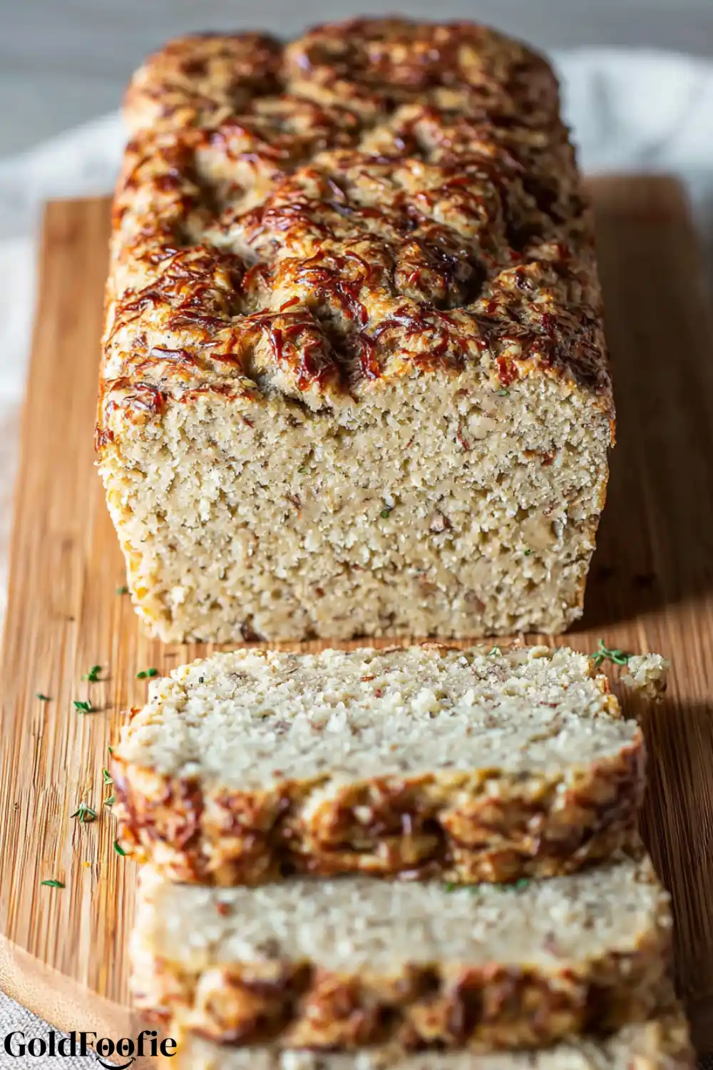 Cheesy Jalapeño Coconut Flour Bread A sliced loaf of cheesy coconut flour bread on a wooden cutting board.