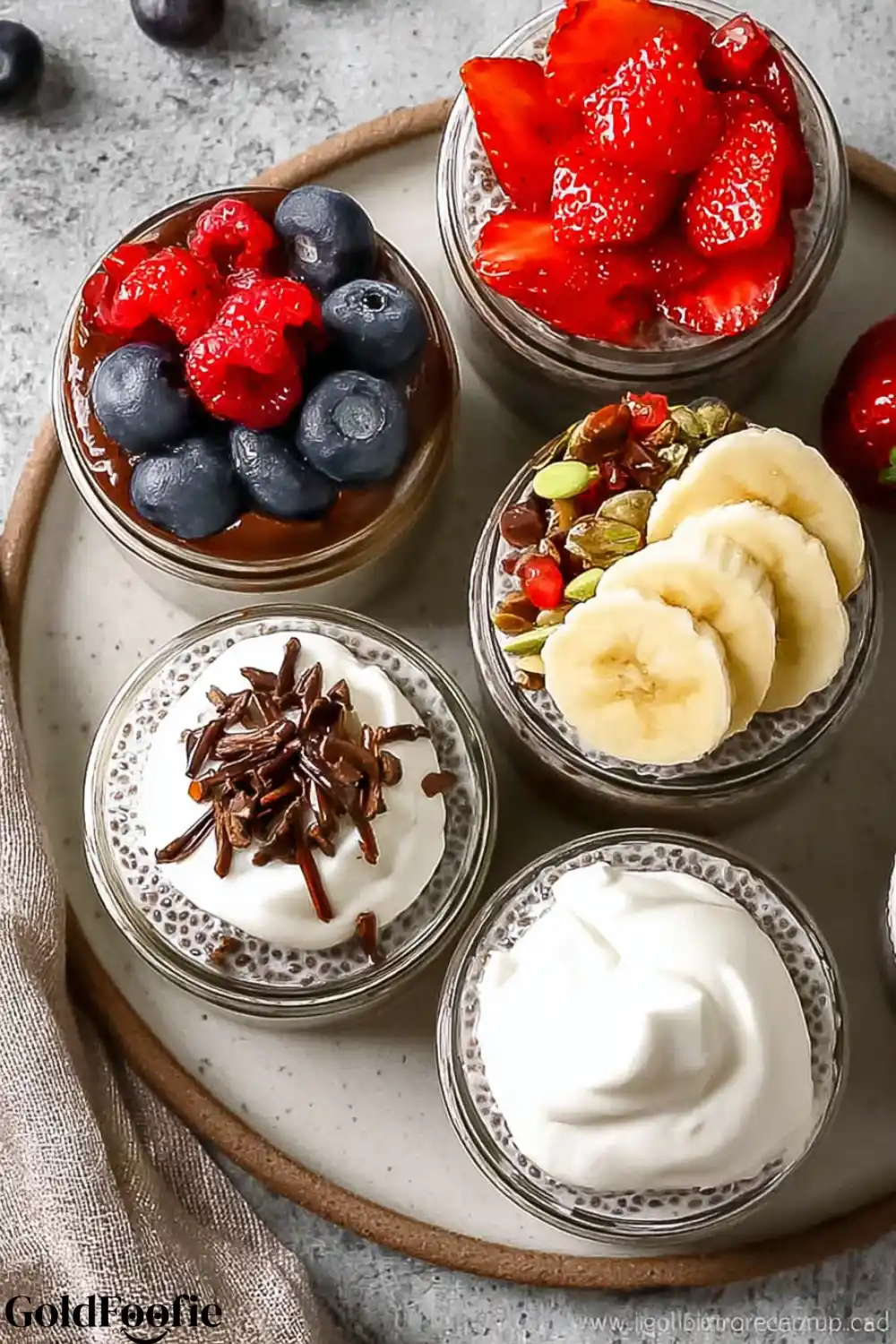 Chia Pudding Dessert Cups with Toppings Assorted chia puddings topped with whipped cream, berries, banana, and seeds