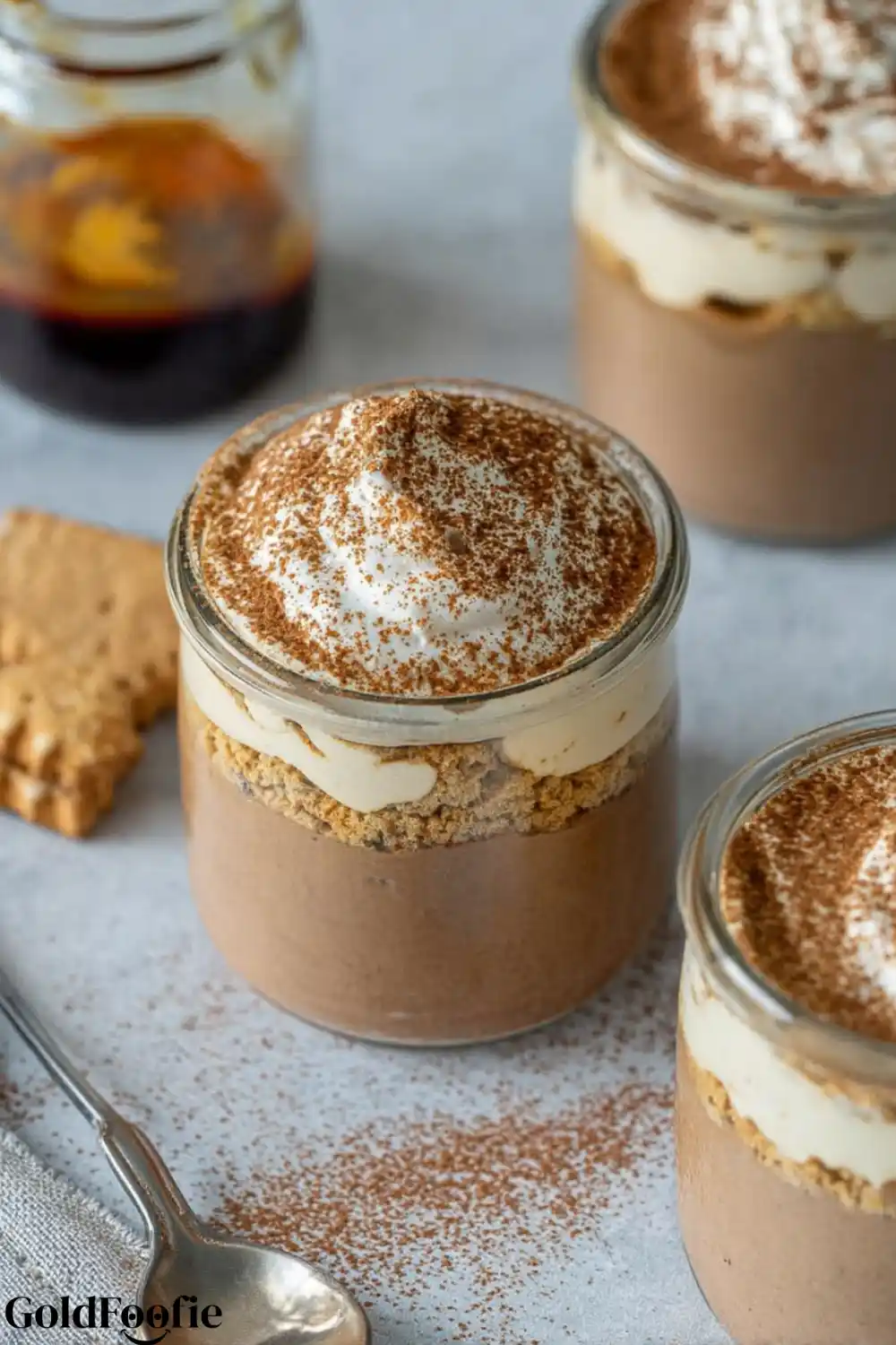 Classic Coffee Chia Tiramisu in a Jar Tiramisu chia pudding with cocoa-topped cream and espresso in background