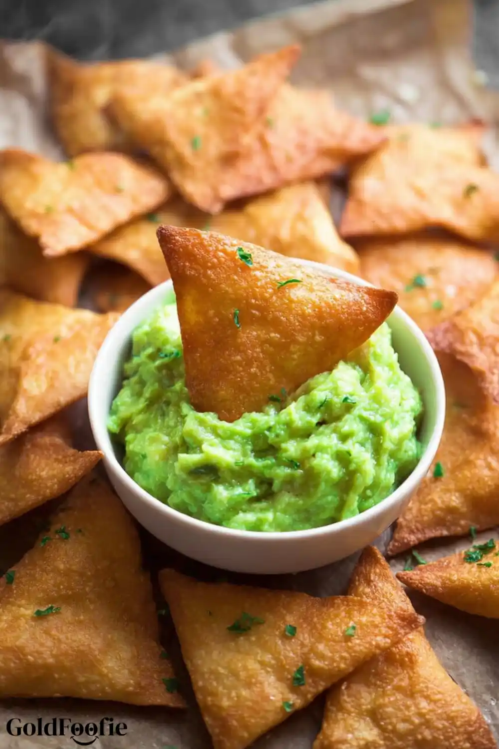Dipping Crunchy Low-Carb Chips into Fresh Guacamole Keto tortilla chip dipped in guacamole