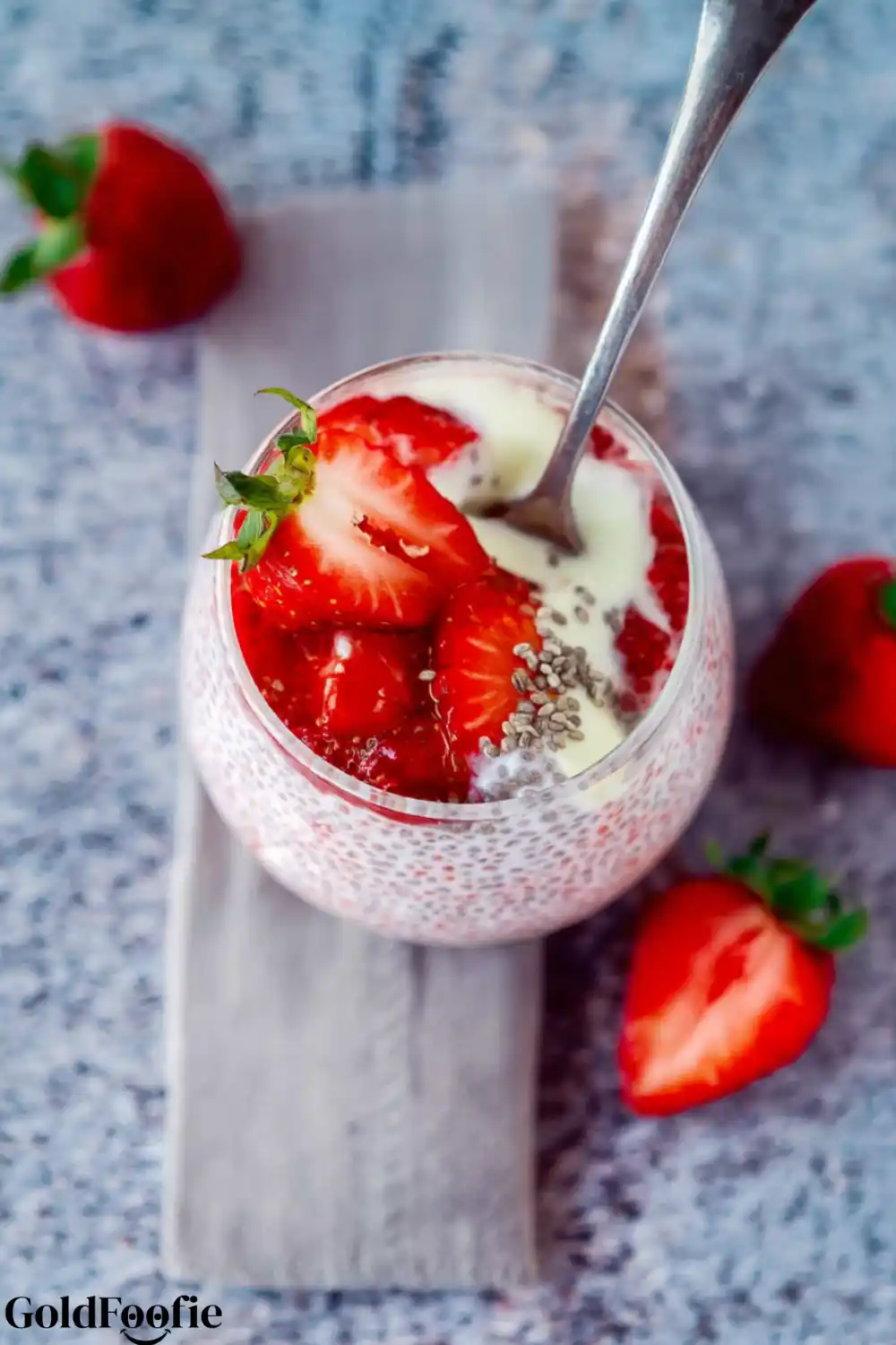 Healthy Strawberry Chia Pudding Jar Overhead view of strawberry chia pudding with cream and seeds