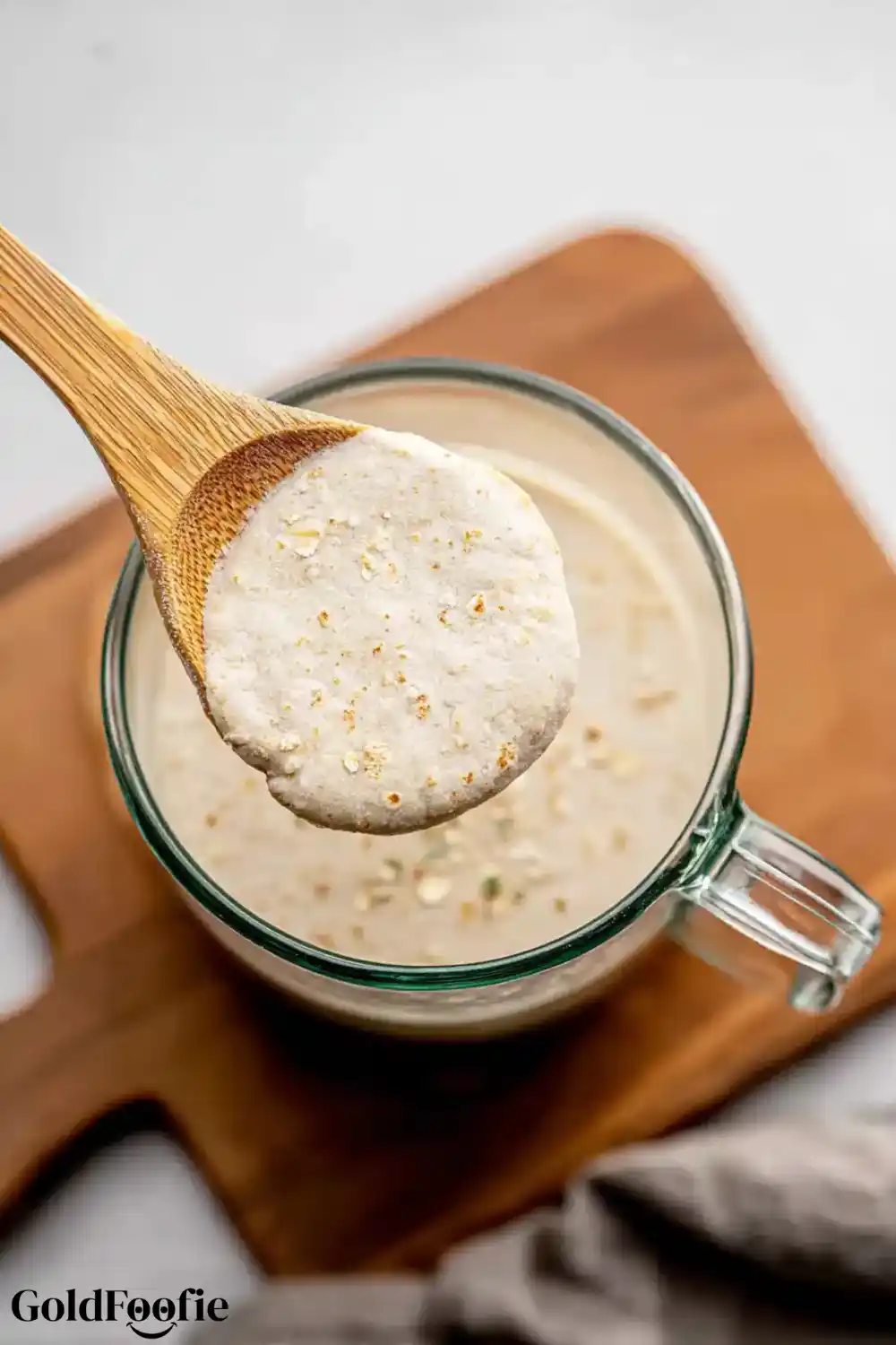 Oat Tortilla Batter Spoon Test Wooden spoon holding blended oat batter over a bowl