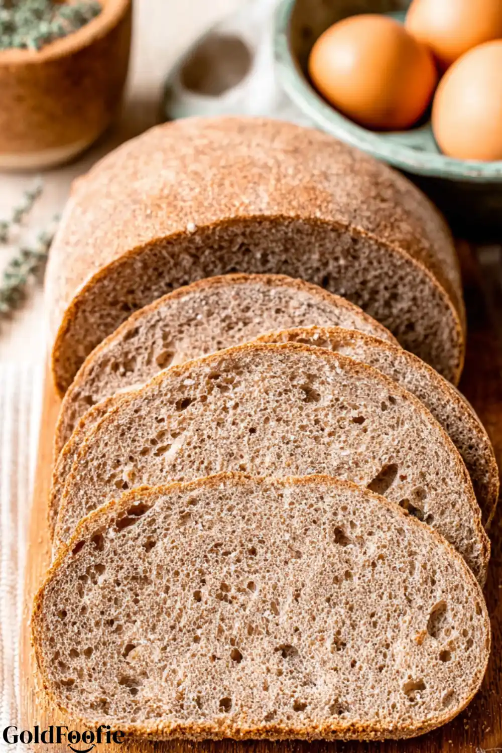 Low-Carb Bread Soft Gluten-Free Loaf Recipe 5 A close-up of a sliced loaf of homemade low-carb bread on a cutting board.