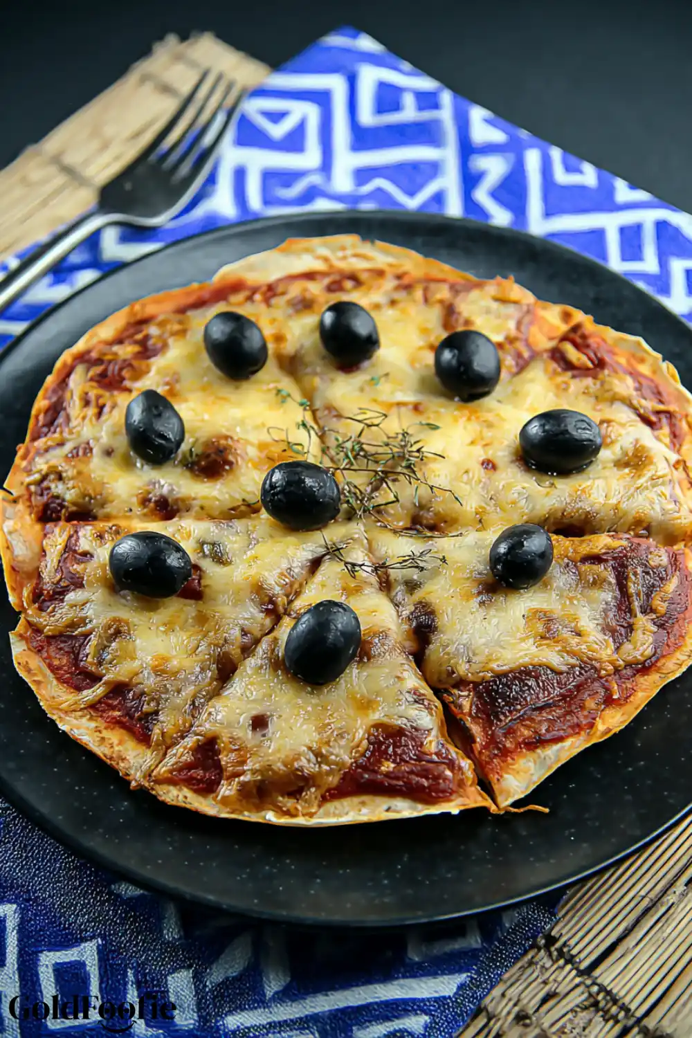 Sliced Pizza with Low Carb Tortilla Crust Sliced pizza made with low carb tortilla and topped with black olives and herbs