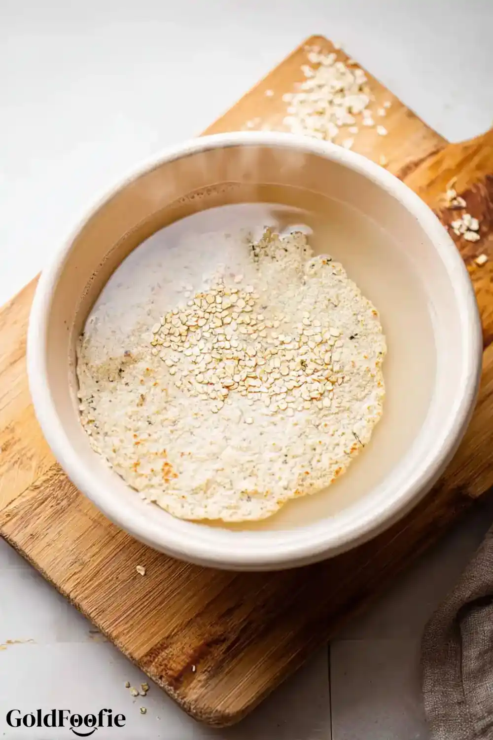 Tortilla Hydration Step Single tortilla soaking in water in a white bowl