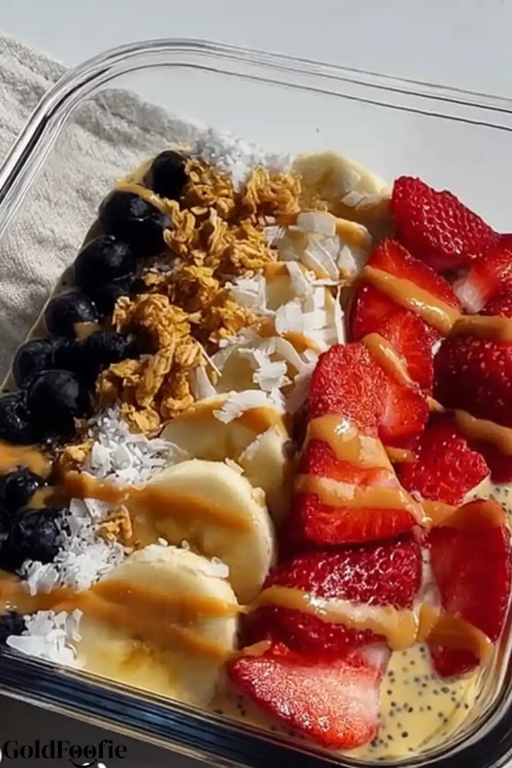 Easy Tropical Smoothie Chia Meal Prep 5 Tropical Smoothie Chia bowl with coconut flakes, sliced strawberries, blueberries, granola, and banana slices