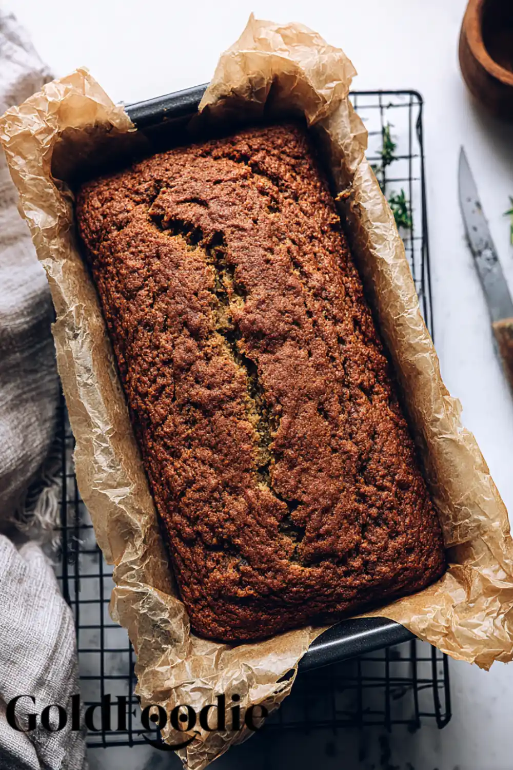Baked Zucchini Bread Loaf A freshly baked loaf of vegan zucchini bread in a pan on a cooling rack.