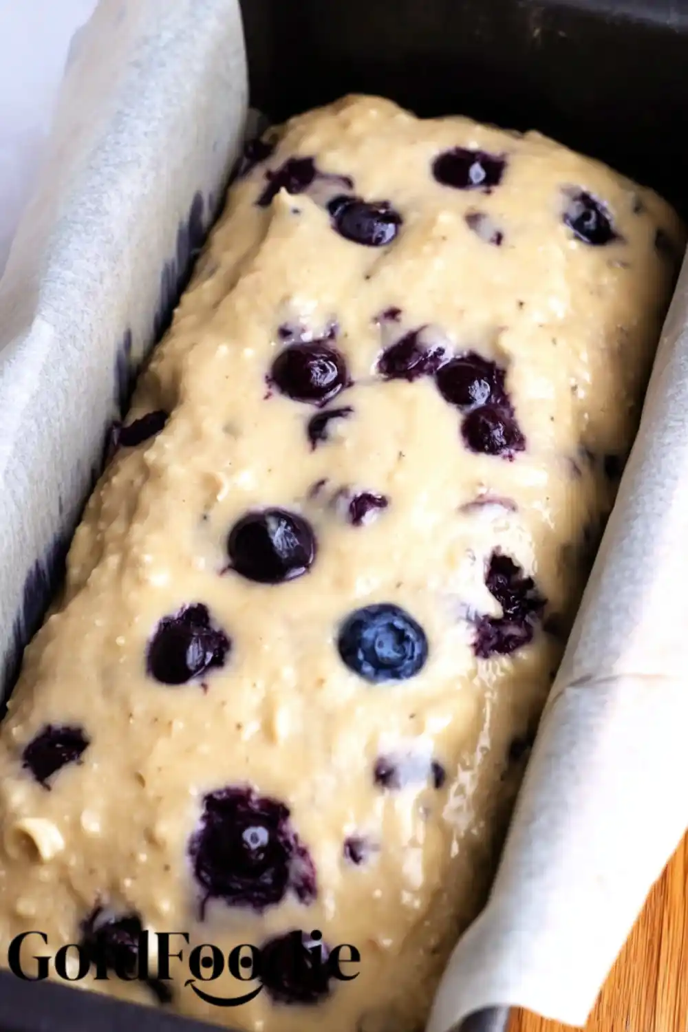 Banana Bread Batter with Blueberries Mashed banana and blueberry batter in a bowl