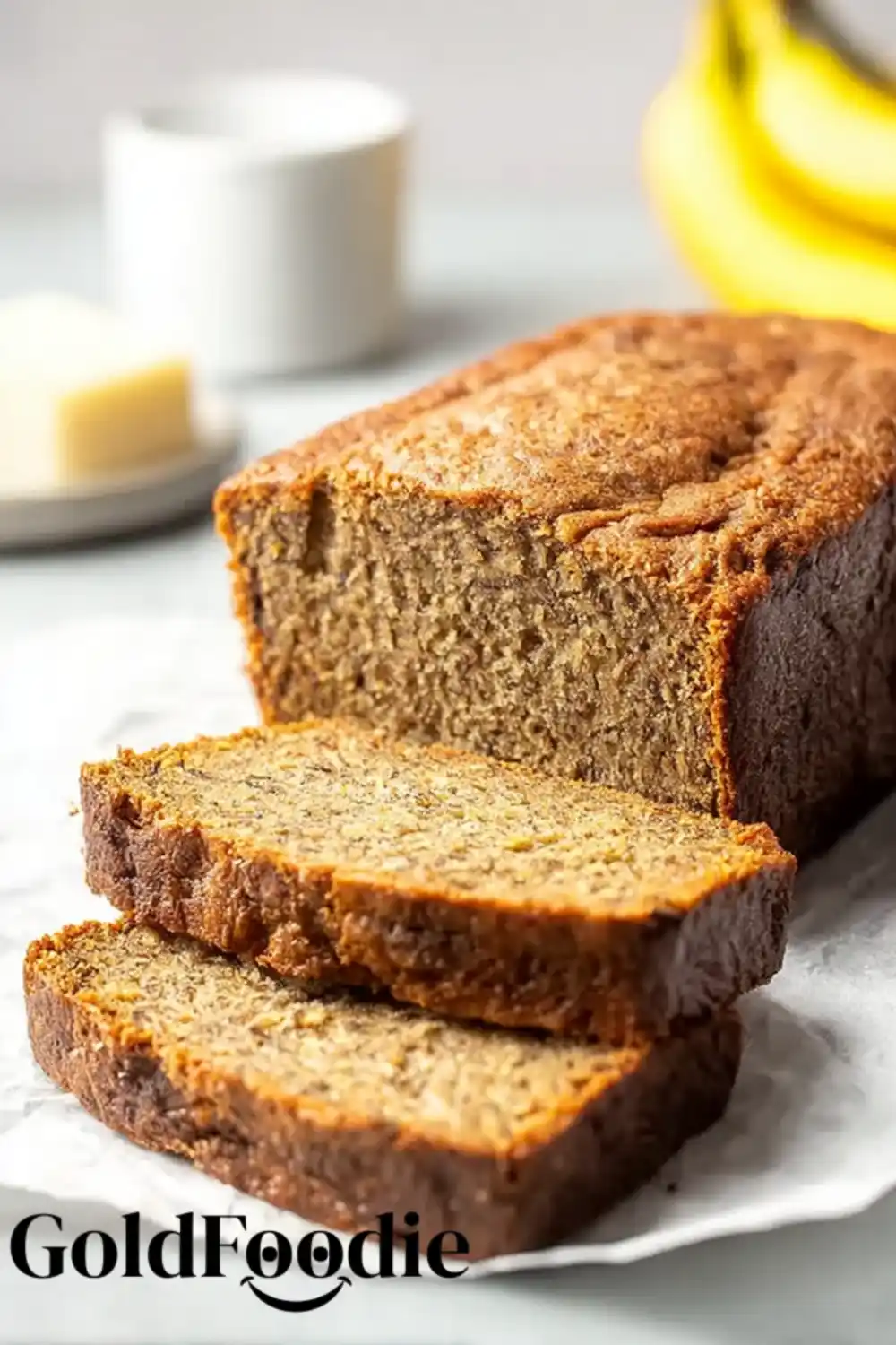 Banana Coconut Bread Slices Coconut Banana Bread loaf with slices in front of bananas.