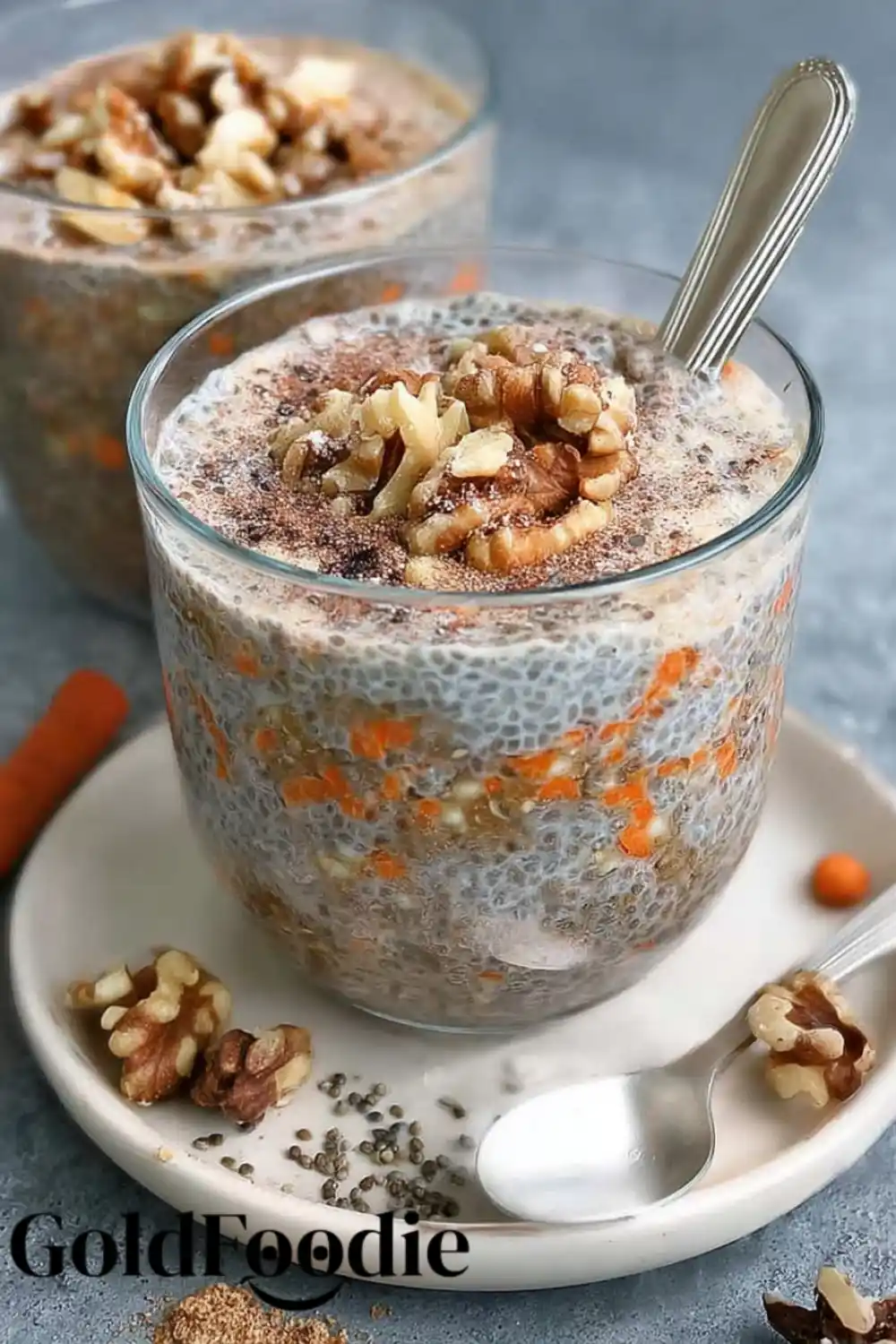 Creamy Chia with Walnuts Set chia pudding in a glass with visible carrots and chopped walnuts on top.