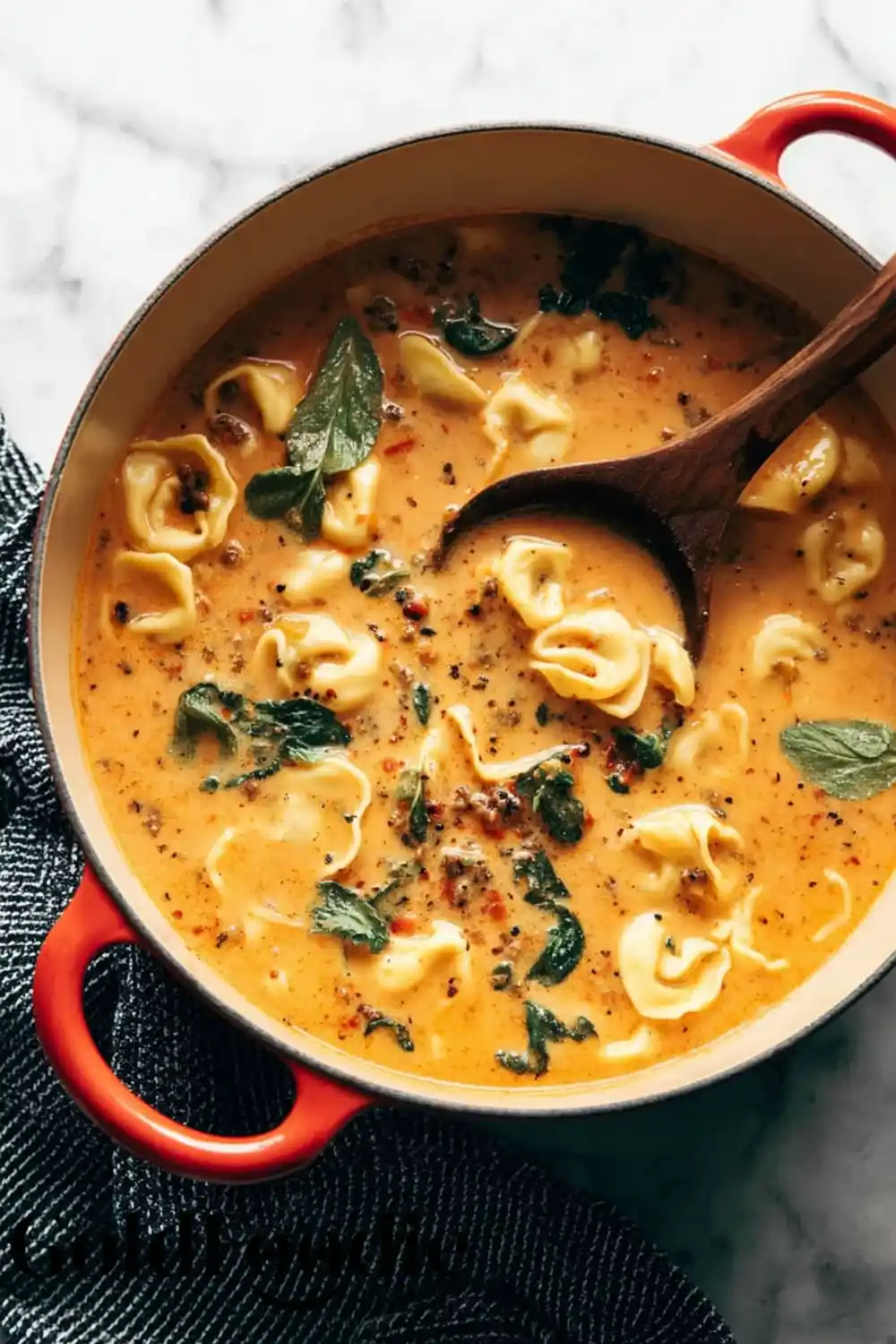 Dutch Oven Tortellini Soup Creamy Tortellini soup simmering in a red Dutch oven with fresh spinach