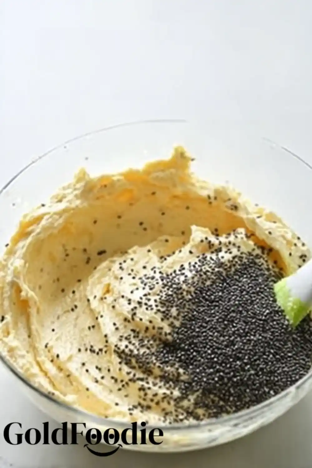 Folding Chia Seeds Mixing chia seeds into orange cake batter with a spatula.