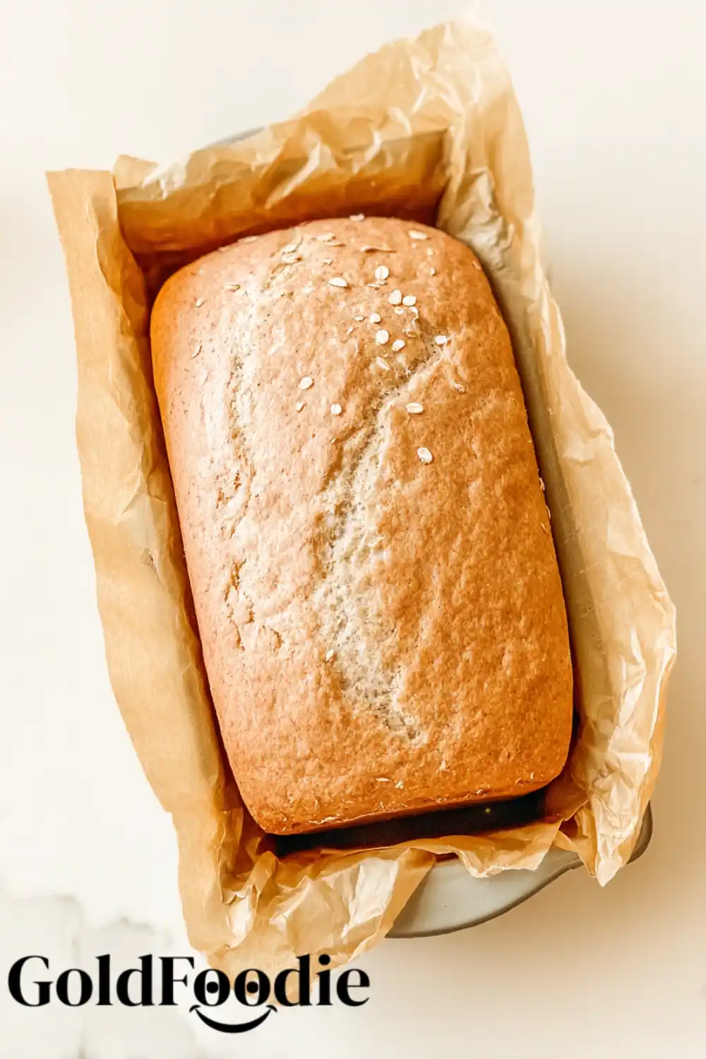 Fresh Baked Bread Baked oat flour bread in a parchment-lined pan.