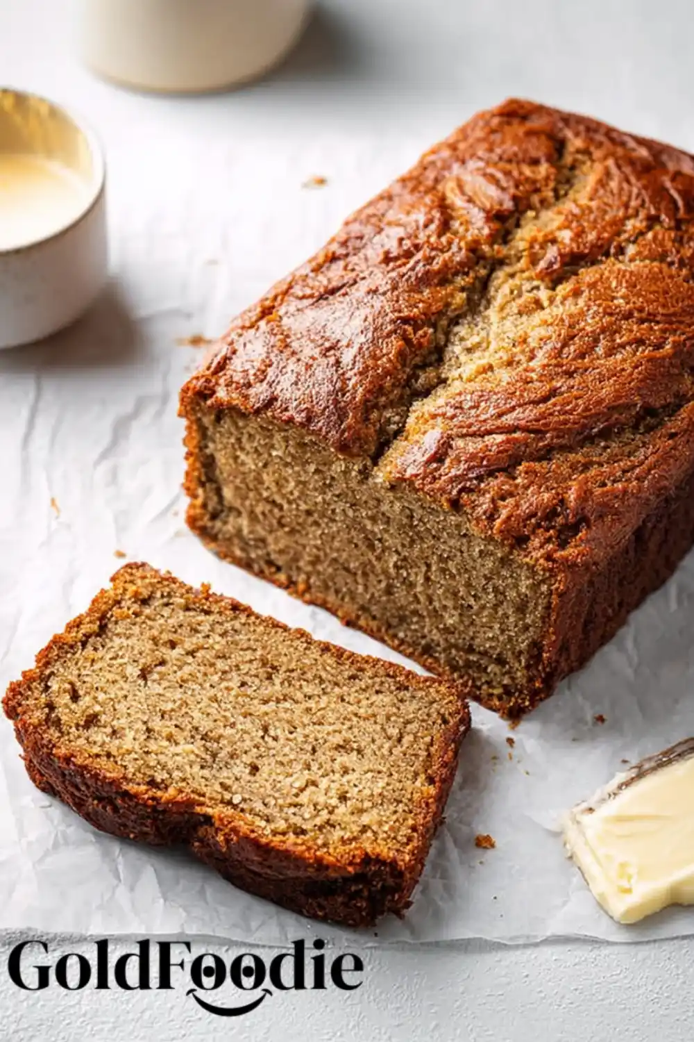 Fresh Coconut Banana Bread Loaf Coconut Banana Bread loaf with one slice cut and butter on the side.