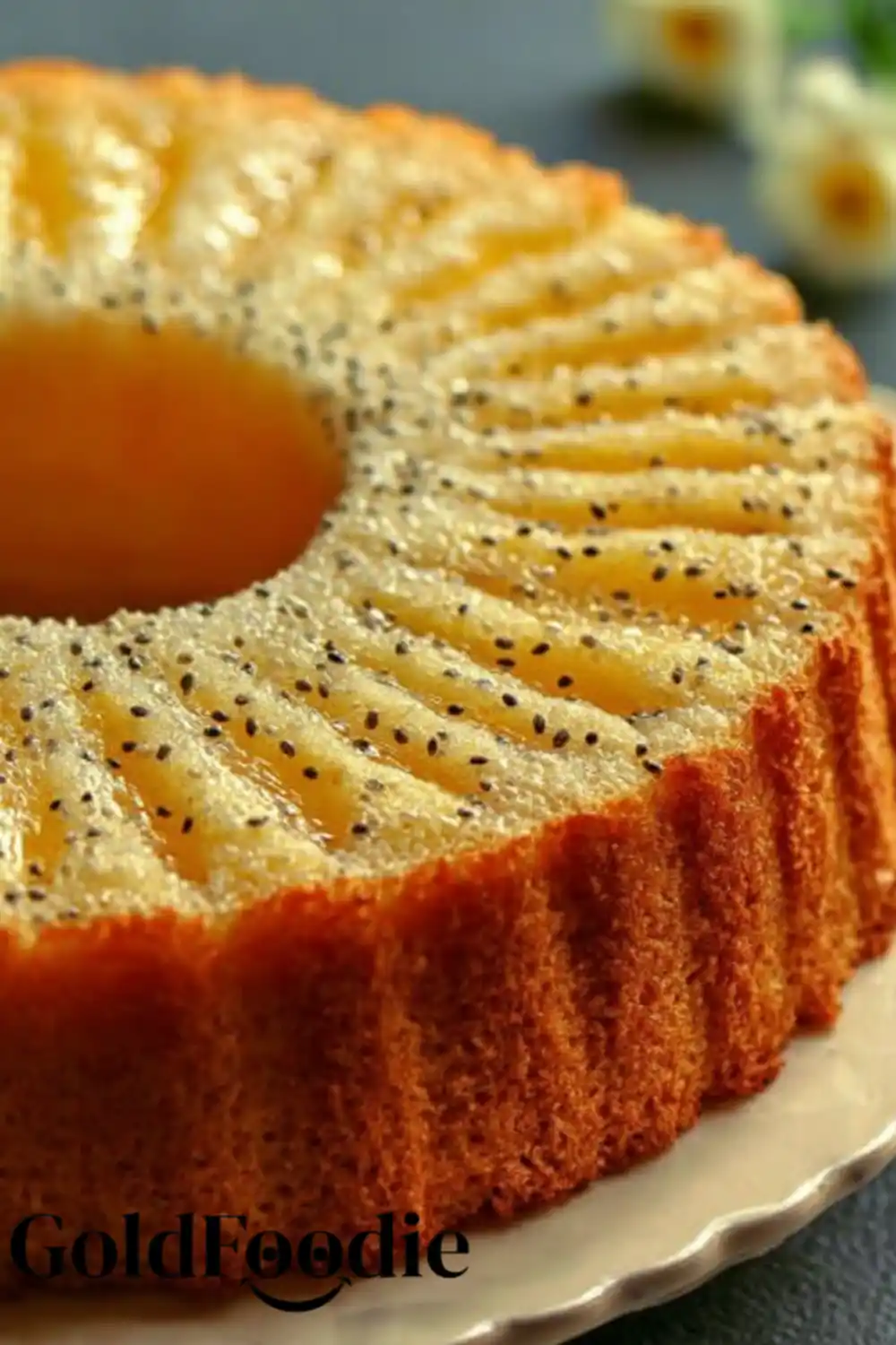 High Protein Orange Chia Cake 5 Full round orange chia cake on a plate, golden and textured with chia seeds.
