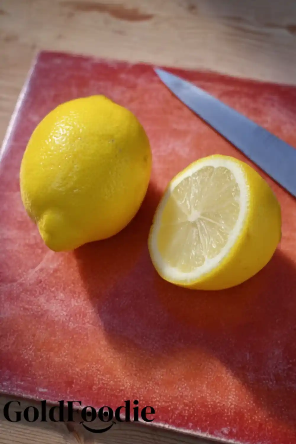 Lemon Cutting Board Whole and halved lemon on a red board