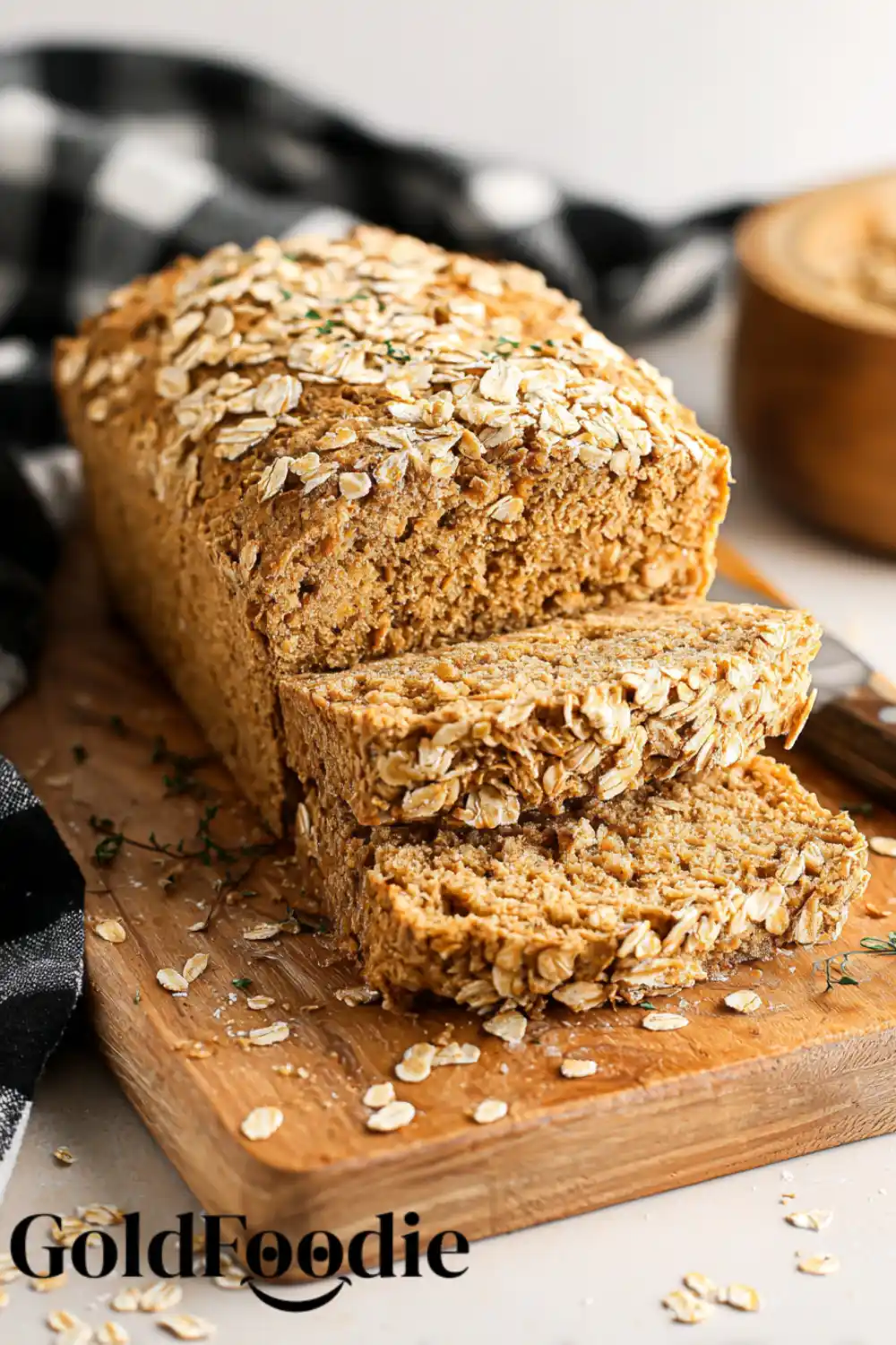 Gluten-Free Vegan Oat Bread Recipe 5 Close-up of oat-topped bread slices stacked on a board.