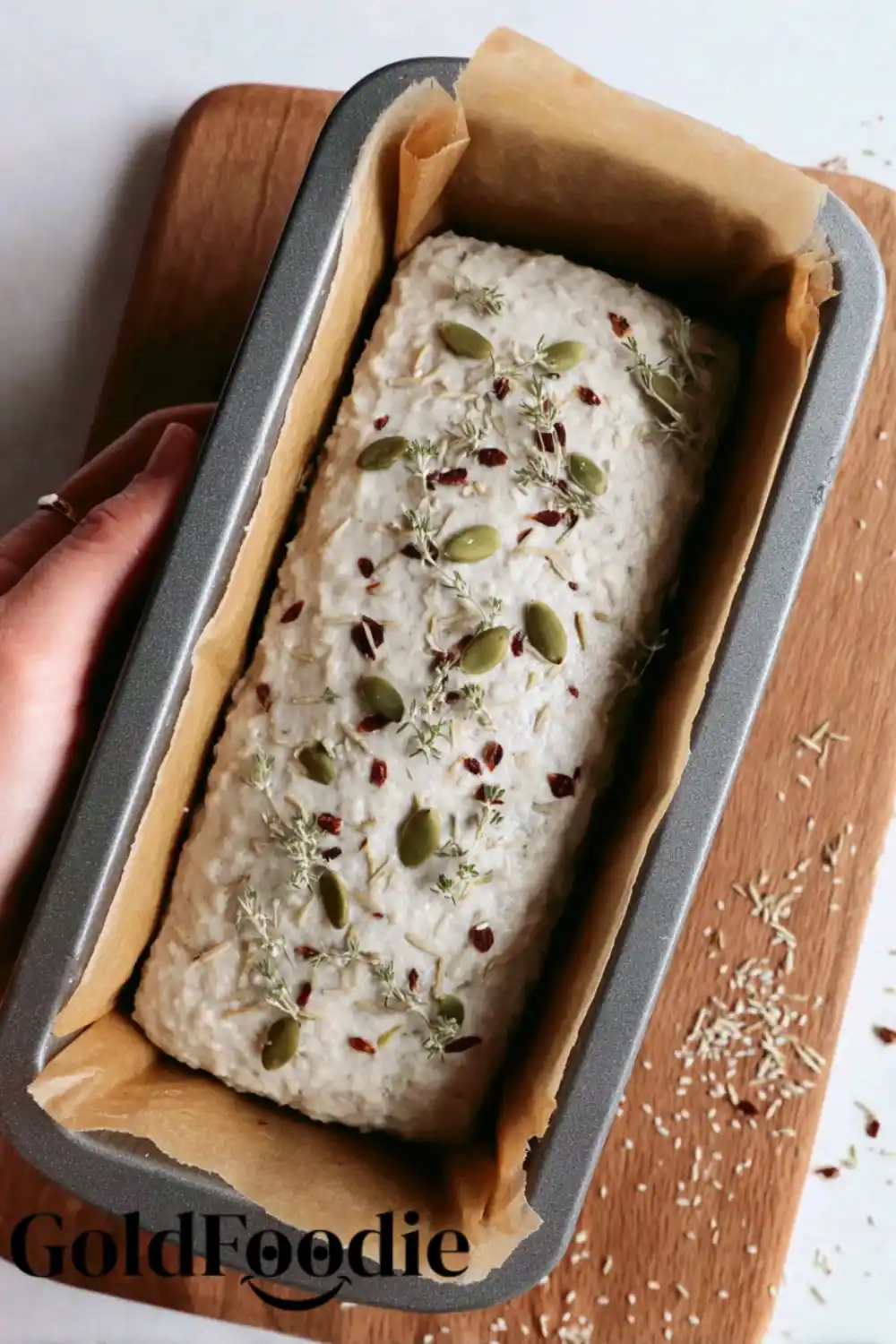 Pre-Bake Almond Bread Bread dough in a loaf tin topped with seeds