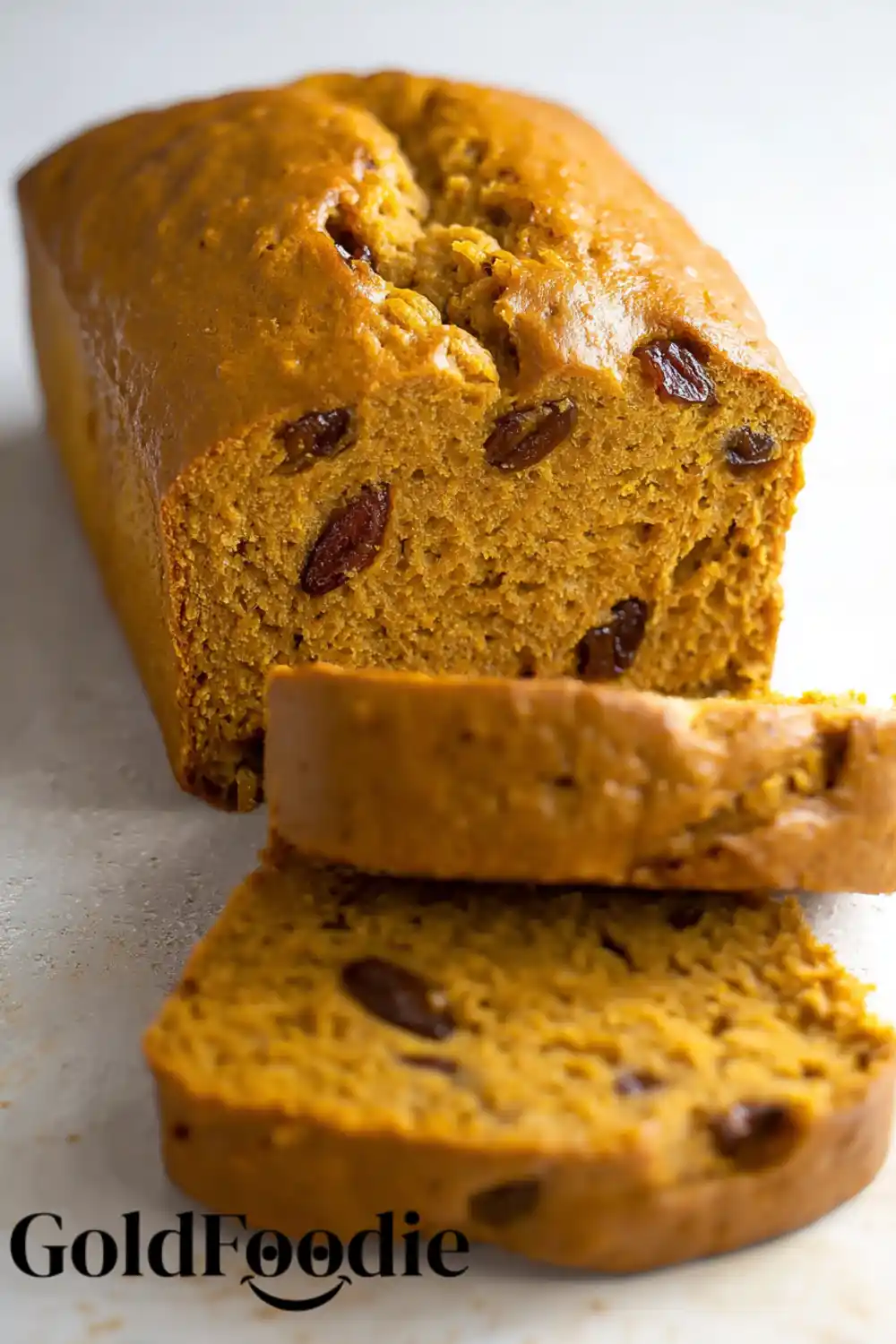 Gluten-Free Vegan Pumpkin Banana Bread 5 Pumpkin banana bread with raisins sliced on a white background.
