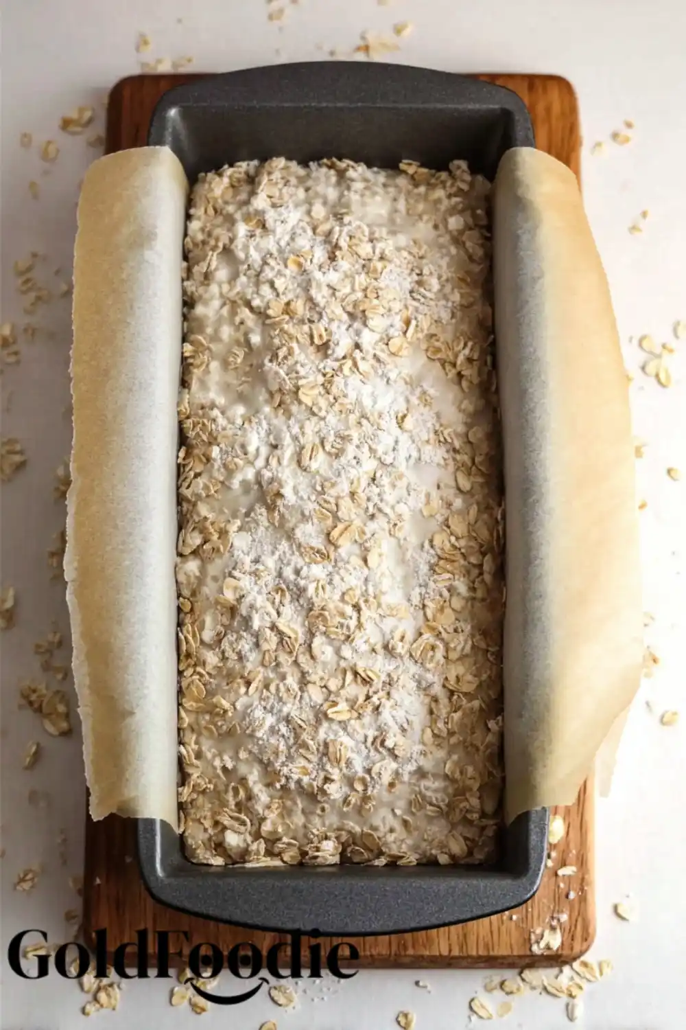 Ready for the Oven Oatmeal bread batter topped with oats in a loaf pan.