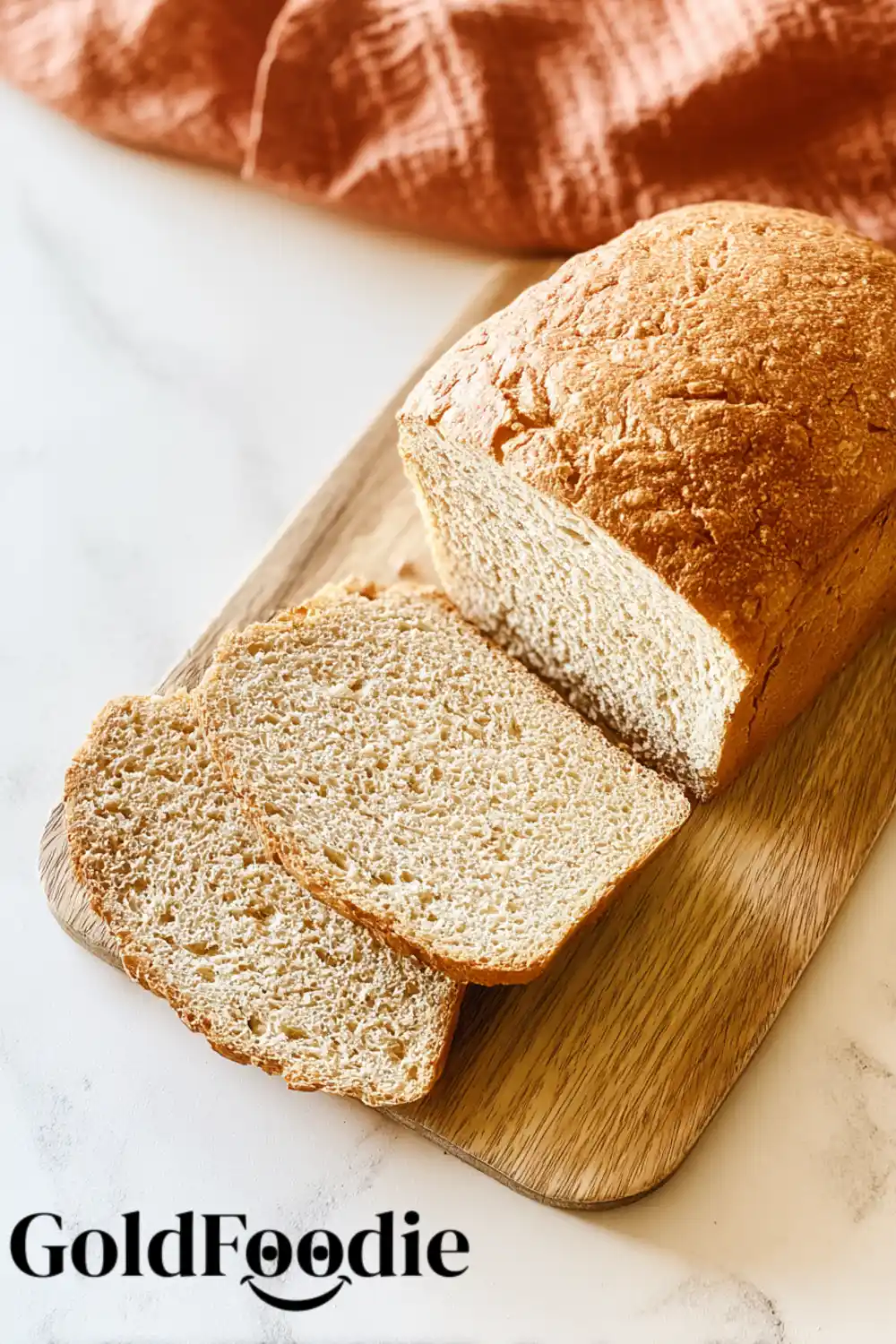 Gluten-Free Vegan Oat Flour Bread 5 Golden loaf of oat flour bread with slices on a board.