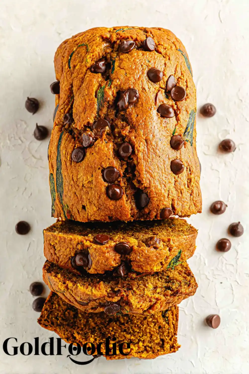 Whole Pumpkin Zucchini Bread Loaf Whole pumpkin zucchini bread loaf with chocolate chips on a light background.