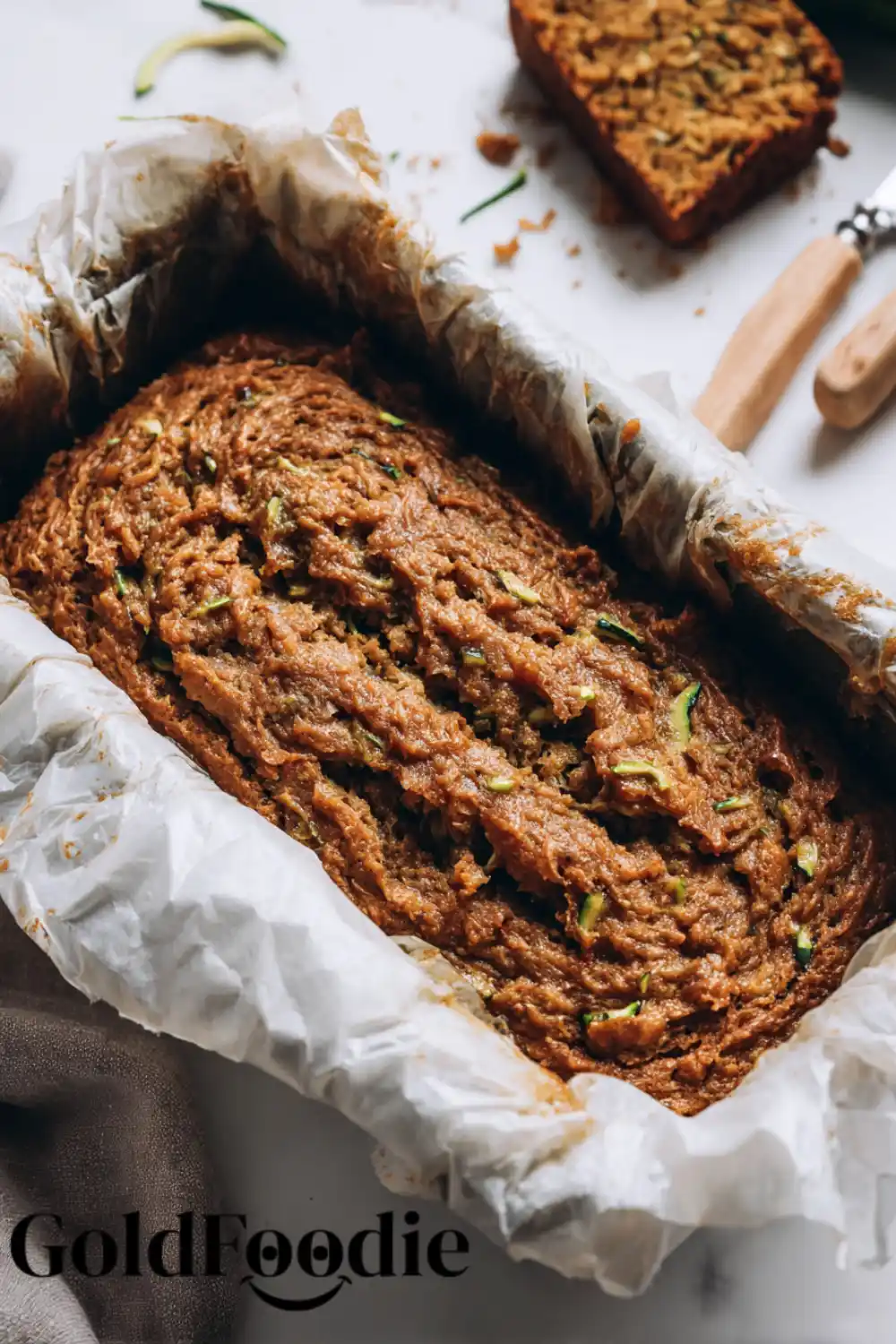 Zucchini Bread Batter Ready to Bake Uncooked vegan zucchini bread batter in a parchment-lined loaf pan.